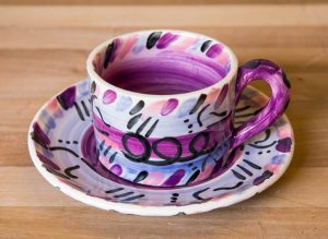 Abstract small cup and saucer in purple