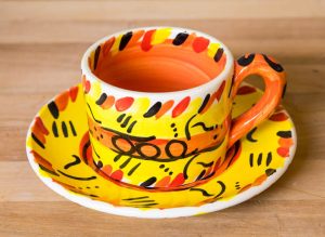 Abstract small cup and saucer in yellow